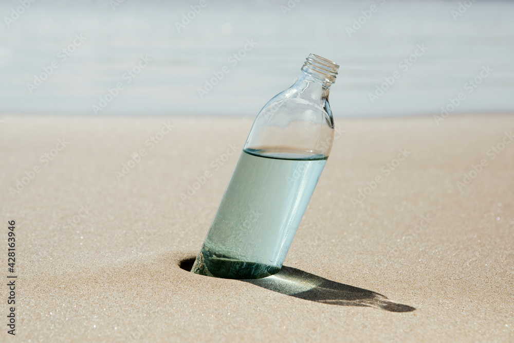 Obraz premium reusable water bottle on the sand of a beach