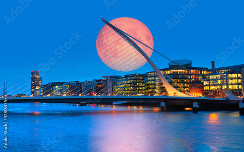 Samuel Backett Bridge (Harp Bridge) at twilight blue hour with full moon - River Liffey, Dublin  Ireland 