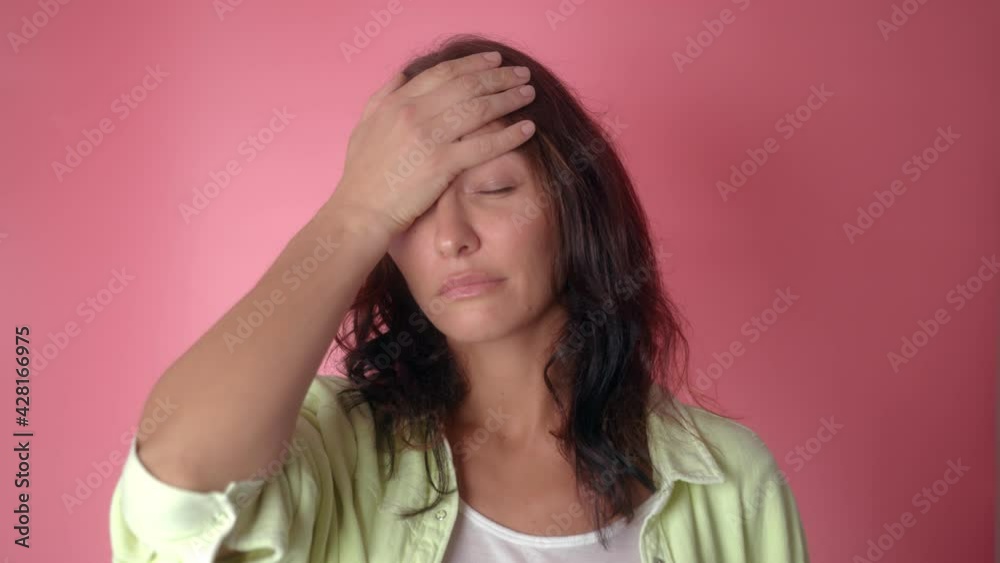 Facepalm, Upset worried brunette woman slapping hand on face and expressing shame, blaming for troubles, feeling helpless isolated on pink background Facepalm, Upset worried brunette woman slapping hand on face and expressing shame, blaming for troubles, feeling helpless isolated on pink background