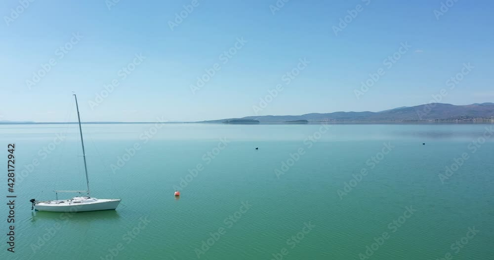 Beautiful drone view of sailing boat on Lake Trasimeno in Umbria, central Italy. Beautiful drone view of sailing boat on Lake Trasimeno in Umbria, central Italy.
