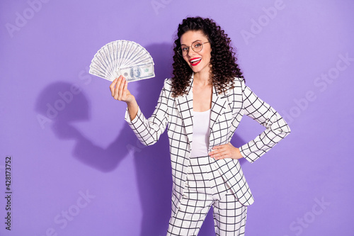Photo of young business woman happy positive smile hold cash money dollar banknotes rich isolated over purple color background © deagreez