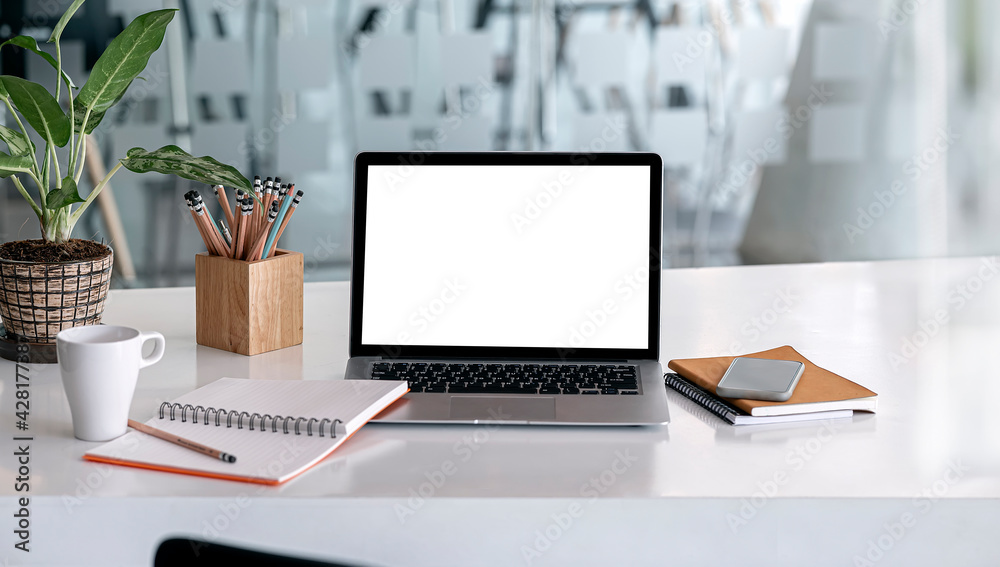 Fototapeta premium Mockup blank screen laptop and supplies on white wooden table.