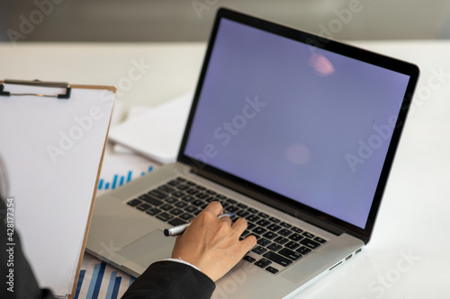 Close up Young woman working on his laptop with blank copy space screen for your advertising text message in office, Back view of business woman hands busy using laptop at office desk