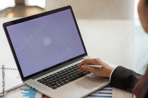 Close up Young woman working on his laptop with blank copy space screen for your advertising text message in office, Back view of business woman hands busy using laptop at office desk