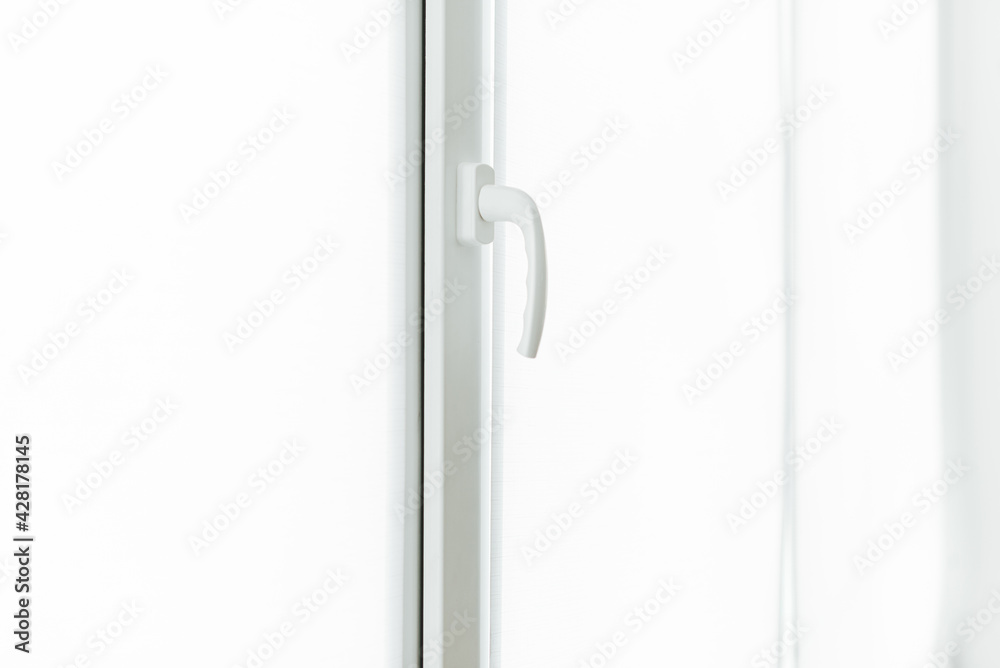 Close up photo of a white window handle on daytime.