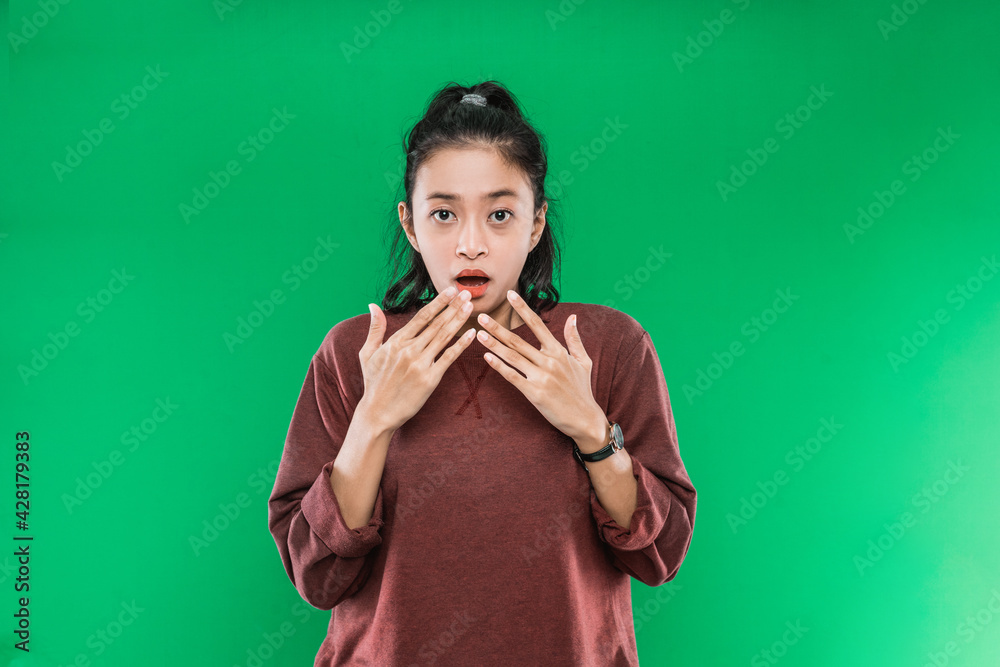 young woman surprised expression mulut terbuka sambil menutupinya dengan kedua tangan and looked confused on green background young woman surprised expression mulut terbuka sambil menutupinya dengan kedua tangan and looked confused on green background