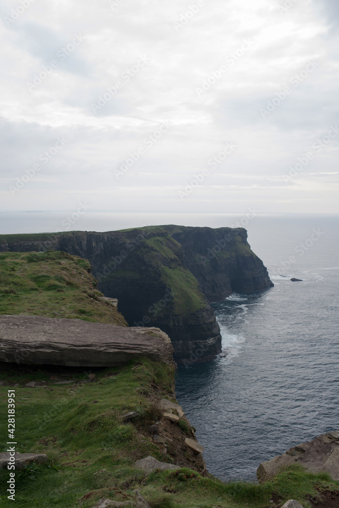 Cliffs of Moher on a rainy day. Green fields and calm water. Ireland, Europe