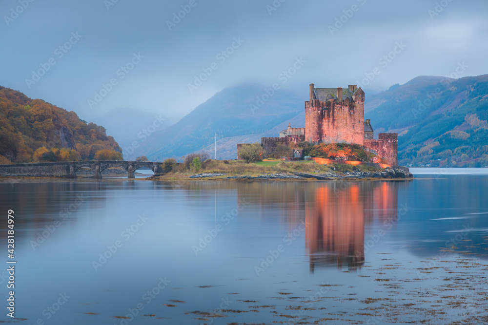 Calm idyllic night at the historic medieval Eilean Donan Castle, illuminated with reflection on Loch Duich in the Scottish Highlands, Scotland.