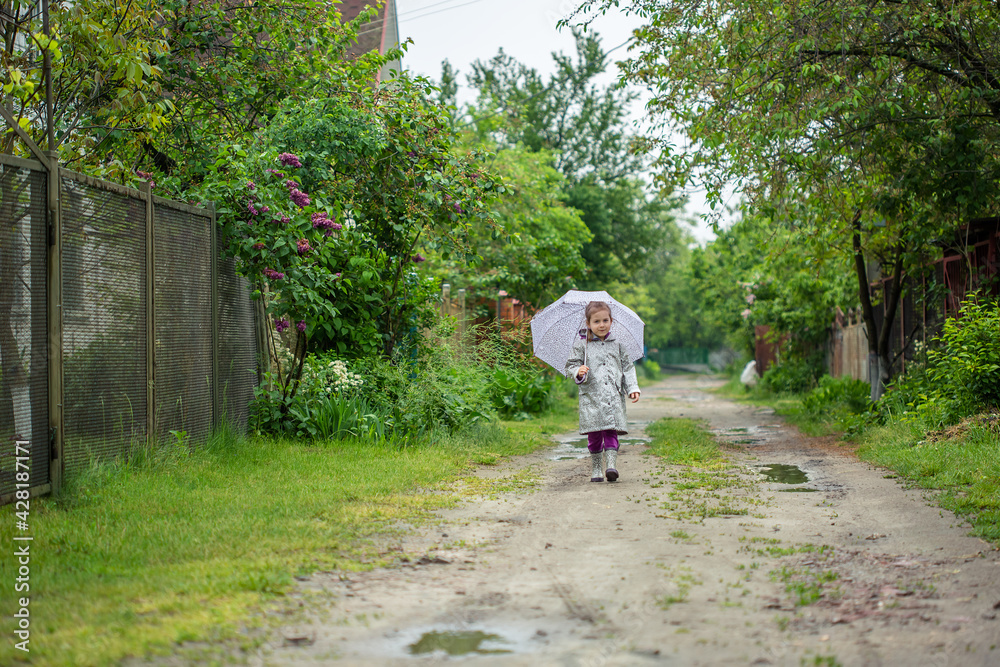 Fototapeta premium summer walk in the rain little girl with an umbrella