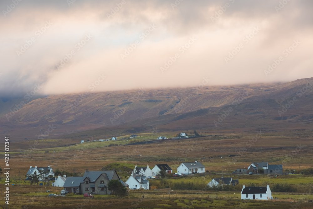 Moody, dramatic golden light over rural countryside landscape of Trotternish Ridge and Staffin village on the Isle of Skye, Scotland. - obrazy, fototapety, plakaty 