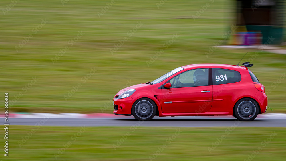 A panning shot of a racing car as it circuits a track.