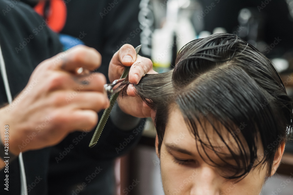 Hipster client man visiting in barber shop shaving hair. Modern guy having his hair cut in barbershop.