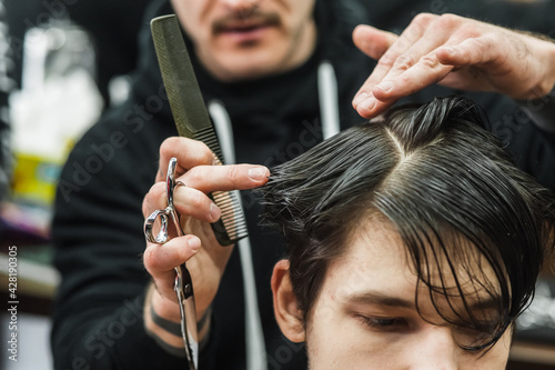 A man in a barbershop.Modern guy having his hair cut in barbershop