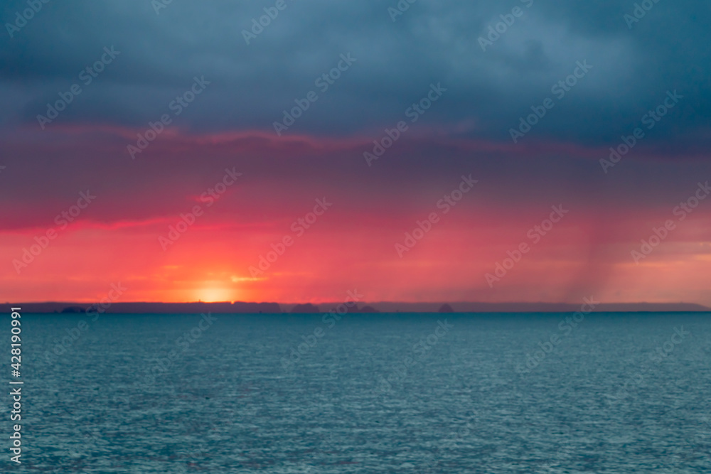Background of dramatic sunrise on the sailing boat with tranquil sea water and epic morning sky, romantic Britanny coastline, Finistere, France