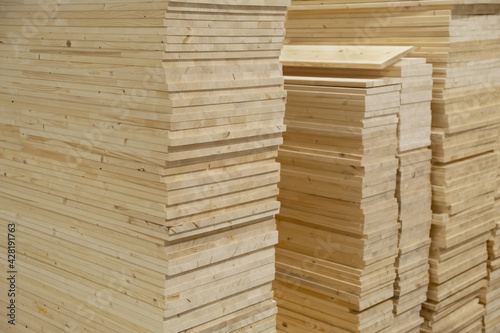 Stacks of pine wood planks in a store or on building site. Natural rough wooden boards boards, lumber, industrial wood, timber