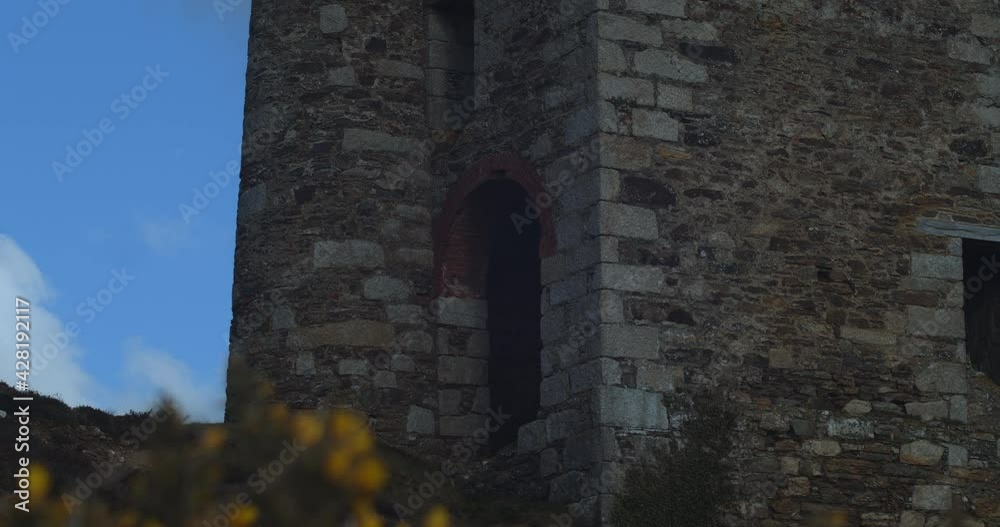 Old stone mine in Cornwall as flowers bloom in foreground, slider reveal Old stone mine in Cornwall as flowers bloom in foreground, slider reveal