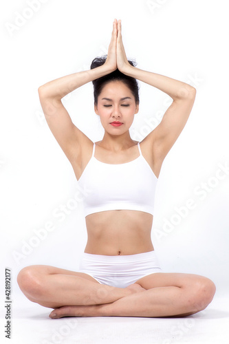 Young woman doing yoga wear white clothes in studio on white background.