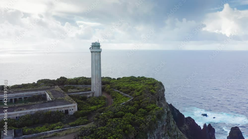 Lighthouse of Ponta dos Rosais. Sao Jorge, Azores, Portugal. Aerial footage a beautiful volcanic island with the ocean behind. Beautiful vacation spot with a lighthouse. High quality 4k footage Lighthouse of Ponta dos Rosais. Sao Jorge, Azores, Portugal. Aerial footage a beautiful volcanic island with the ocean behind. Beautiful vacation spot with a lighthouse. High quality 4k footage