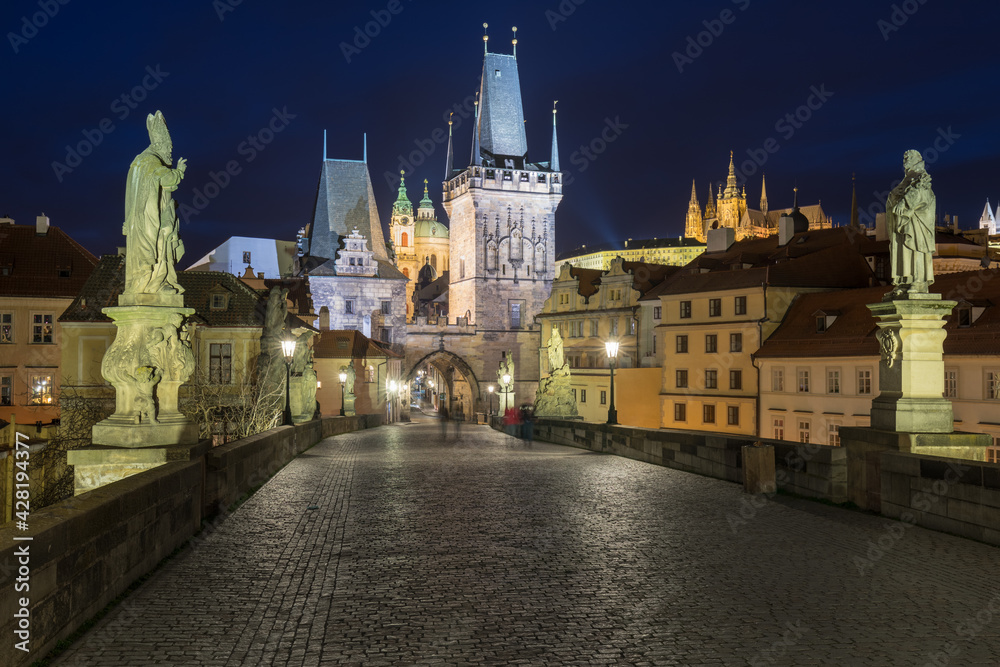 Scenic view on Vltava river, Charles bridge and historical center of Prague, buildings and landmarks of old town at sunrise or dusk, Prague, Czech Republic. Beautiful gothic buildings.