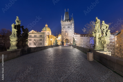 Scenic view on Vltava river, Charles bridge and historical center of Prague, buildings and landmarks of old town at sunrise or dusk, Prague, Czech Republic. Beautiful gothic buildings.