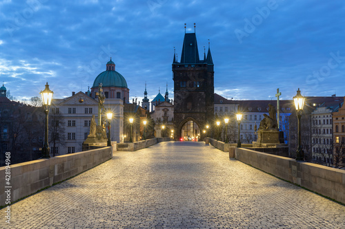 Scenic view on Vltava river, Charles bridge and historical center of Prague, buildings and landmarks of old town at sunrise or dusk, Prague, Czech Republic. Beautiful gothic buildings.