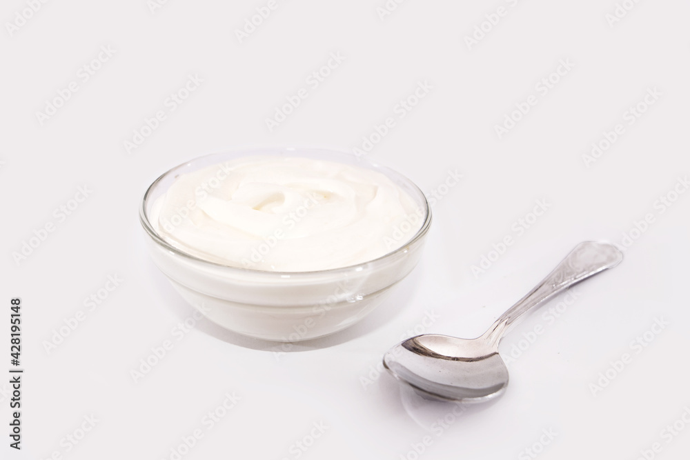 sour cream in a plate and spoon, mayonnaise, yogurt isolated on white background sour cream in a plate and spoon, mayonnaise, yogurt isolated on white background