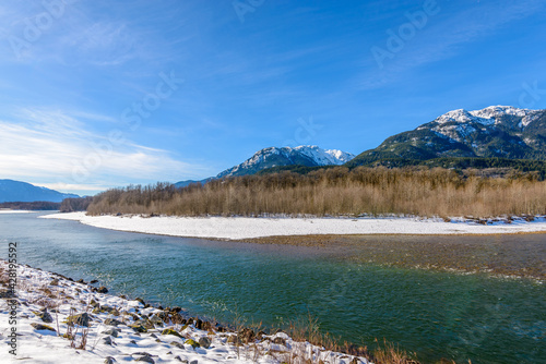 Majestic mountain river in winter over snow mountains and blue sky in Vancouver  Canada.