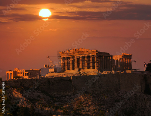 sun and fiery sky over Parthenon temple on Acropolis of Athens, Greece