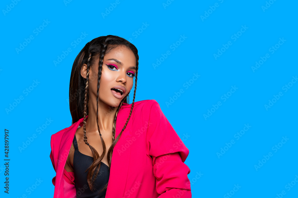 Fashion Portrait black Woman in pink stylish jacket. neon pink Makeup. Fashion model African American posing on blue background studio. Fashion Portrait black Woman in pink stylish jacket. neon pink Makeup. Fashion model African American posing on blue background studio.