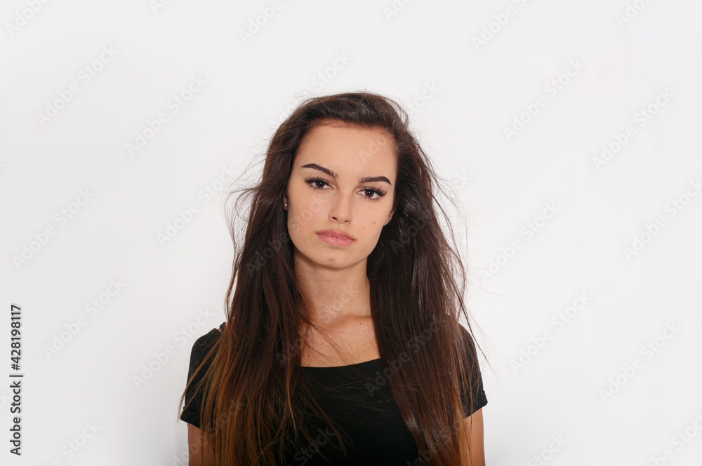 Beautiful young woman with brunette hairstyle with no make-up, standing frontal looking at camera over white background. Beautiful young woman with brunette hairstyle with no make-up, standing frontal looking at camera over white background.