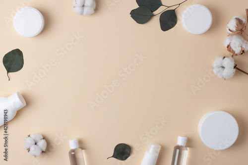 Cosmetic background with skin care products and flowers on pink. Flat lay, copy space photo