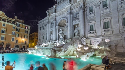 The famous Trevi Fountain at night timelapse hyperlapse. This place is one of the most visited in Rome. Crowd stay agound. photo