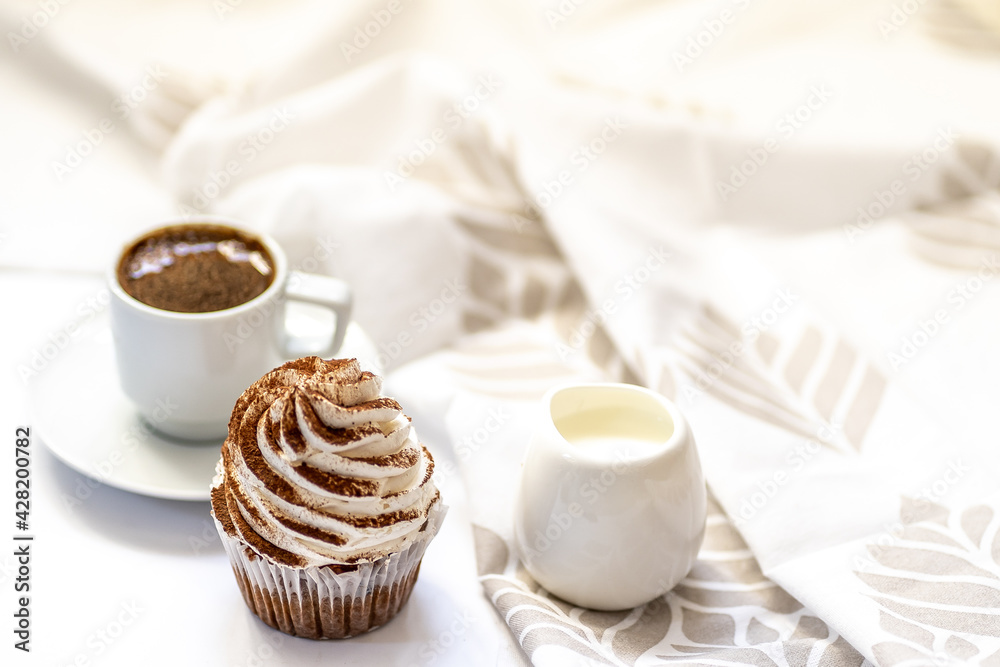 Black coffee with cupcakes and muffins. Spice cupcakes with creamcheese frosting decorated with a cocoa Black coffee with cupcakes and muffins. Spice cupcakes with creamcheese frosting decorated with a cocoa