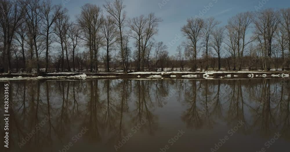Snowy spring shore with trees. Congestion on the River in the Spring. Floating chunks of ice in a muddy river. Aerial drone shot at spring sunny day. Snowy spring shore with trees. Congestion on the River in the Spring. Floating chunks of ice in a muddy river. Aerial drone shot at spring sunny day.