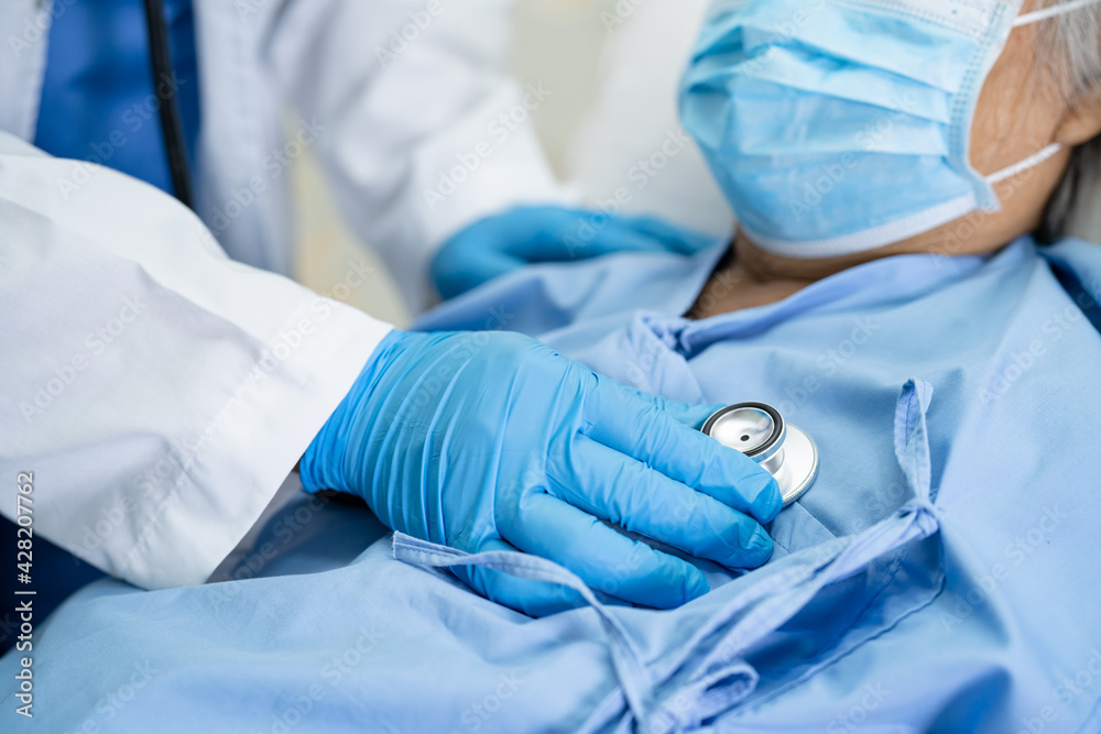 Doctor using stethoscope to checking Asian senior or elderly old lady woman patient wearing a face mask in hospital for protect infection Covid-19 Coronavirus. Doctor using stethoscope to checking Asian senior or elderly old lady woman patient wearing a face mask in hospital for protect infection Covid-19 Coronavirus.