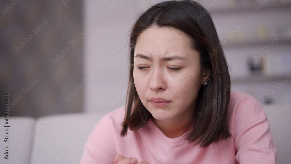 Upset depressed young multi ethnic woman feeling bad stressed worried anxious ashamed, upset nervous asian girl having problem regret unwanted pregnancy need psychological help sitting alone at home Upset depressed young multi ethnic woman feeling bad stressed worried anxious ashamed, upset nervous asian girl having problem regret unwanted pregnancy need psychological help sitting alone at home