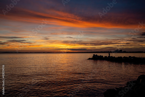 A sunset on the seashore. Soft sea ocean waves wash over golden sand background.