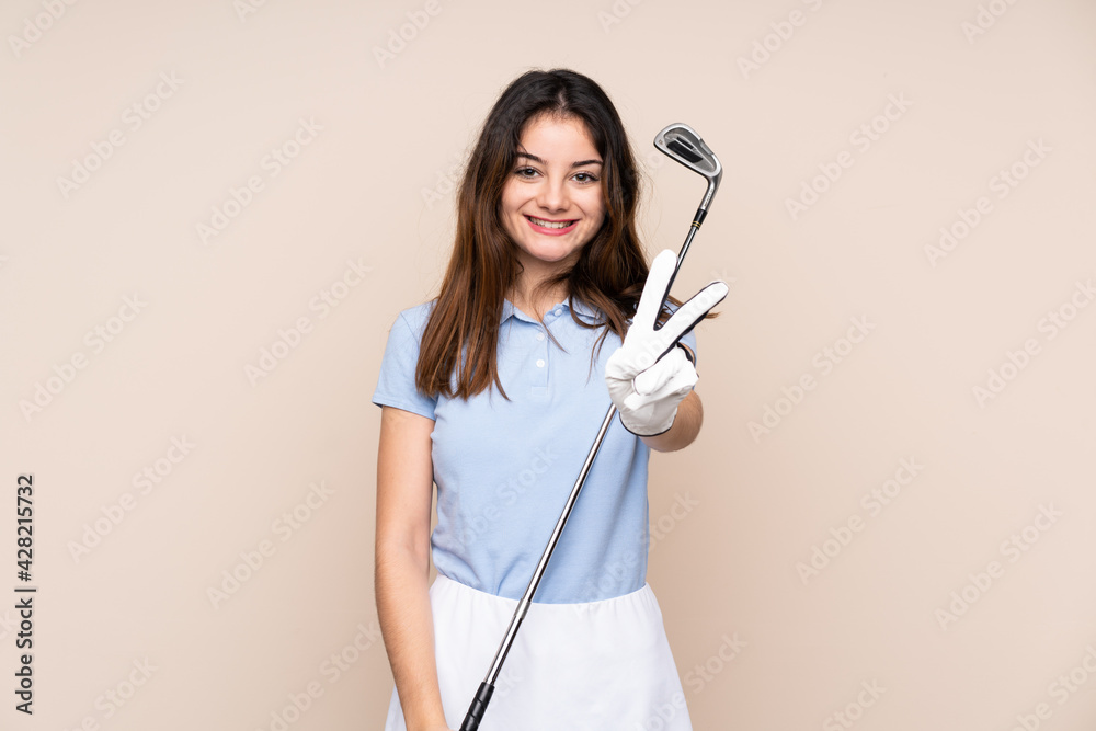 Young caucasian woman isolated on beige background smiling and showing victory sign Young caucasian woman isolated on beige background smiling and showing victory sign