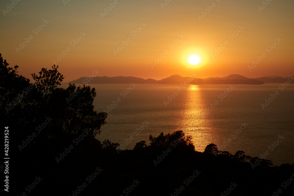 A picturesque view of the warm sea sunset and the mountainous coast