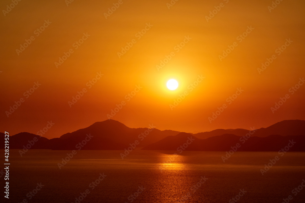 A picturesque view of the warm sea sunset and the mountainous coast