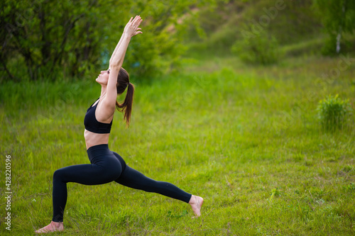 Sporty woman doing yoga and a healthy lifestyle on nature. Outdoor sport © kalinichenkod