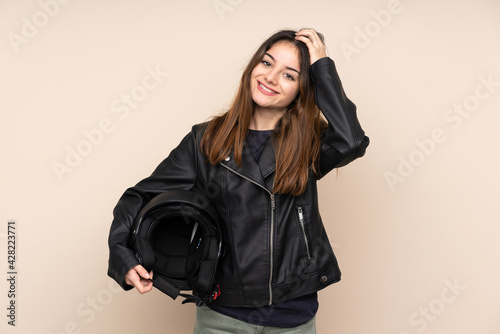 Woman with a motorcycle helmet isolated on beige background laughing