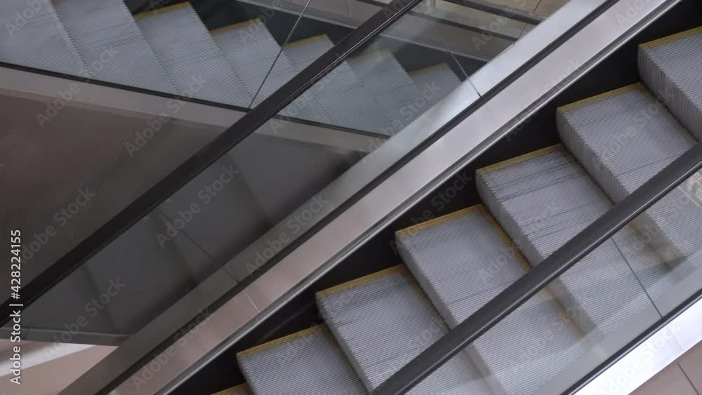 Empty escalators in a business center, mall or airport. Movement of escalator steps. Empty public places and spaces in the city Empty escalators in a business center, mall or airport. Movement of escalator steps. Empty public places and spaces in the city