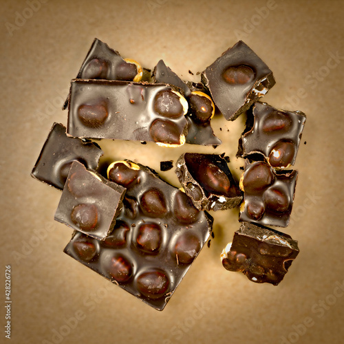  fragments of dark chocolate with whole hazelnuts photo