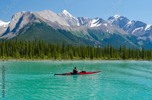 Red canoe at mountain lake. Rocky Mountains, Alberta, Canada.
