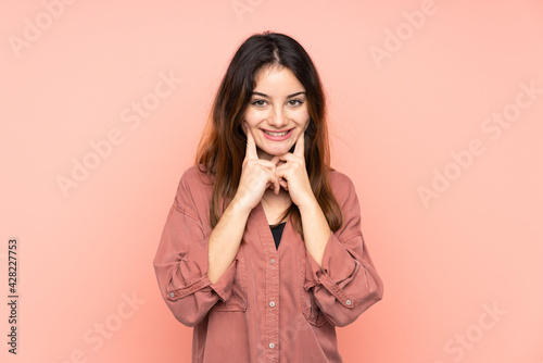 Young caucasian woman isolated on pink background smiling with a happy and pleasant expression