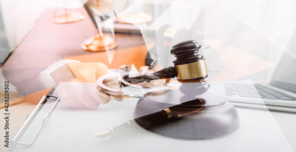 Business and lawyers discussing contract papers with brass scale on desk in office. Law, legal services, advice, justice and law concept picture with film grain effect Business and lawyers discussing contract papers with brass scale on desk in office. Law, legal services, advice, justice and law concept picture with film grain effect