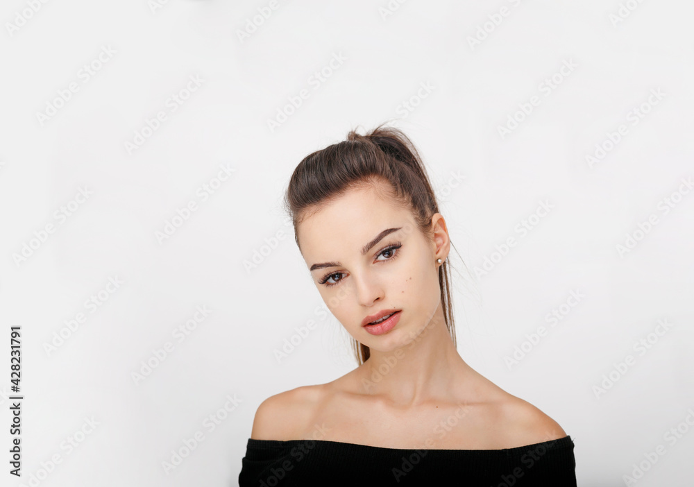 Beautiful woman with brunette ponytail standing frontal looking at camera over white background. Beautiful woman with brunette ponytail standing frontal looking at camera over white background.