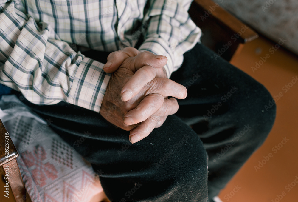 close-up of an old man's hands with wrinkles and age spots.