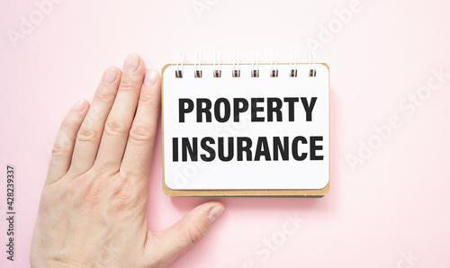 Property insurance protection concept. property insurance text is written on a white sheet of paper held by a business girl.